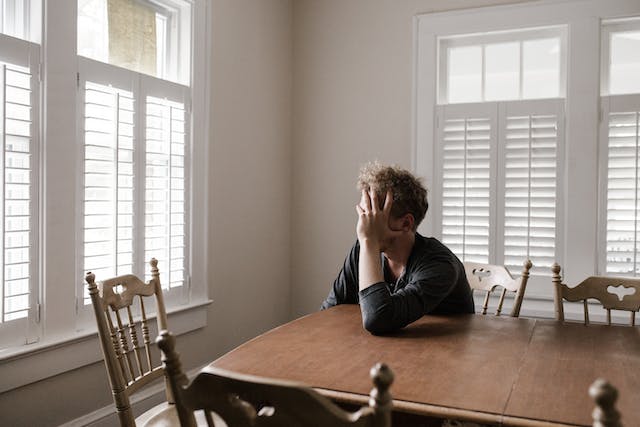 stressed man sitting at table alone