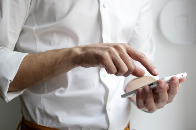 person in white shirt holding phone