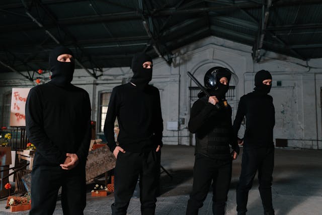 group of people dressed in black wearing ski masks